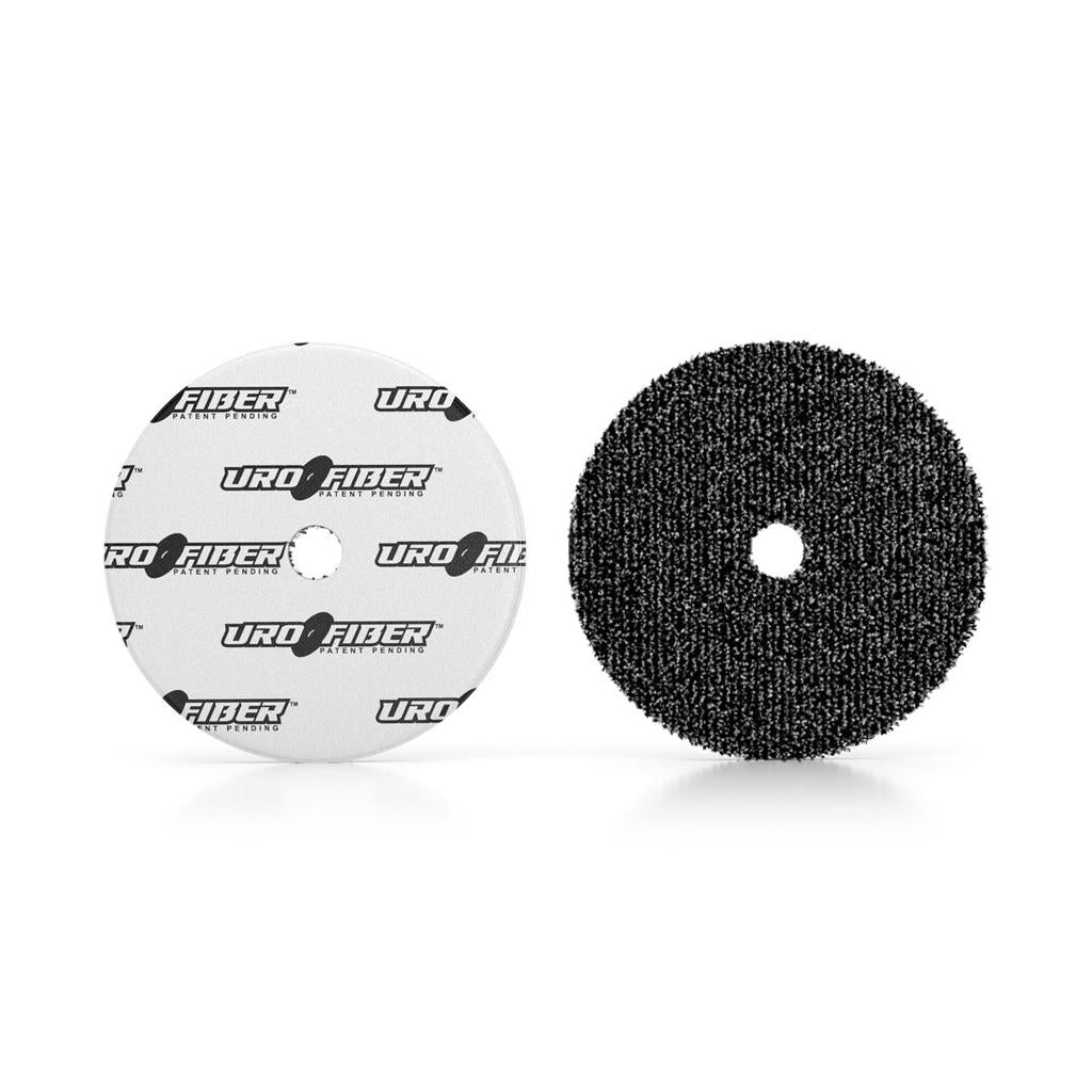 Two polishing pads labeled 'URO FIBER' side by side, one with a white surface and the other with a black textured surface, each with a central hole.