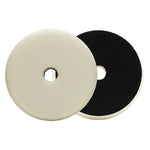 Two polishing pads, one with a white surface and the other with a black surface, both featuring a central hole for attachment.