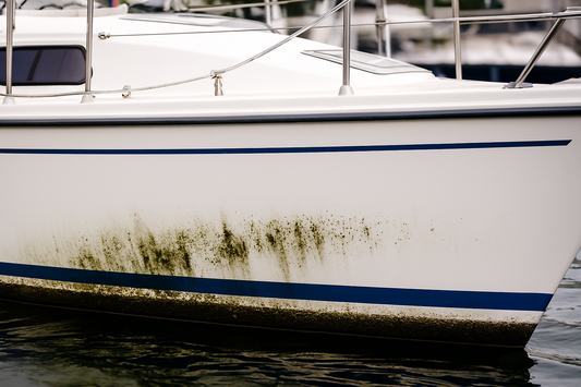 Close-up of a white vinyl boat seat being cleaned to remove visible mold and mildew stains, set against a clean marine environment background.